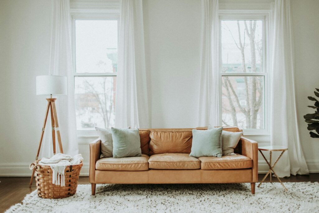 5 Ways Fresh Cleaning 4U Keeps Your Home Sparkling Clean A cozy minimalist living room with a leather sofa and stylish decor.